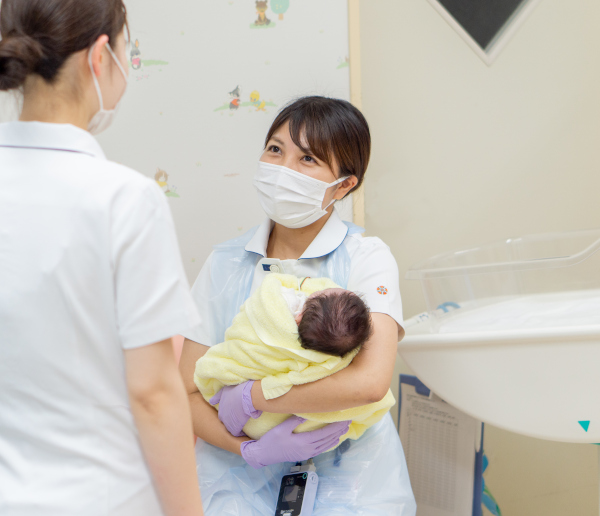 新生児を抱く看護師