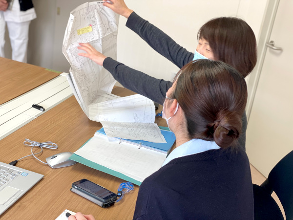 訪問先の場所を確認するスタッフと参加学生
